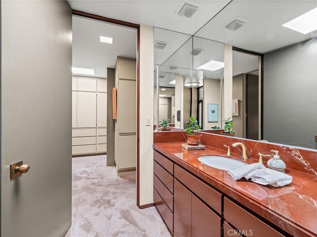 bathroom featuring a skylight, visible vents, and vanity