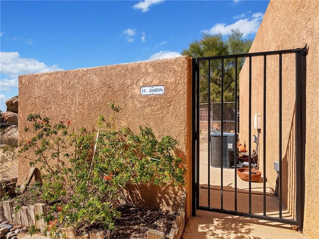 view of gate featuring fence and cooling unit