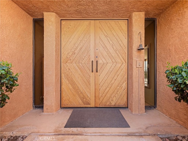 property entrance with stucco siding