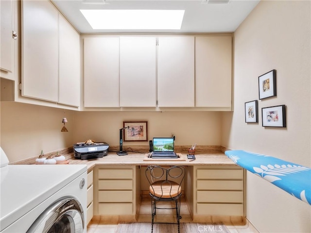 clothes washing area with cabinet space, a skylight, and washer / dryer