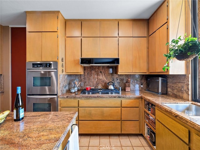 kitchen with appliances with stainless steel finishes, range hood, light tile patterned flooring, and decorative backsplash