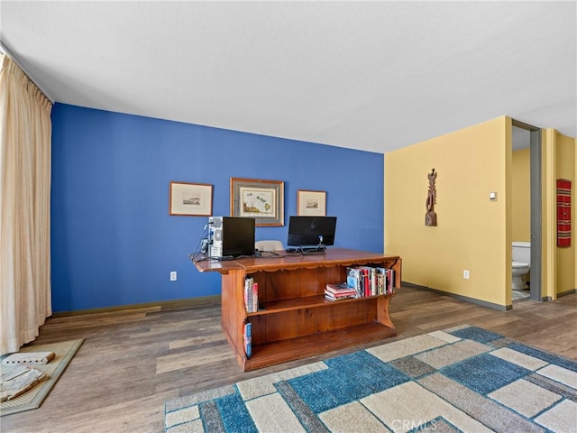 office space with baseboards and wood finished floors