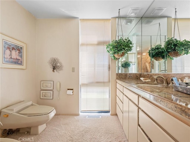 bathroom featuring vanity, toilet, and a shower with door