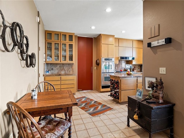 kitchen with double oven, glass insert cabinets, decorative backsplash, and light tile patterned floors