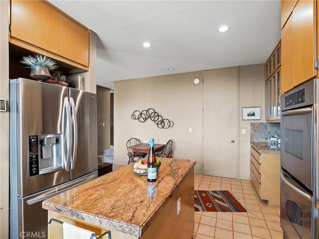 kitchen featuring light tile patterned floors, a kitchen island, appliances with stainless steel finishes, and recessed lighting