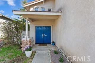 property entrance with stucco siding