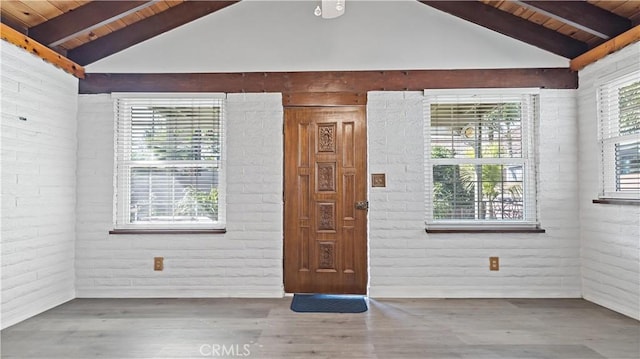 entryway with wooden ceiling, a healthy amount of sunlight, vaulted ceiling with beams, and wood finished floors