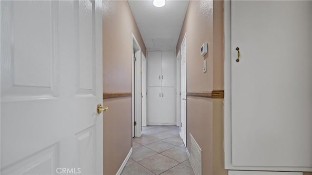 hall featuring light tile patterned floors and visible vents