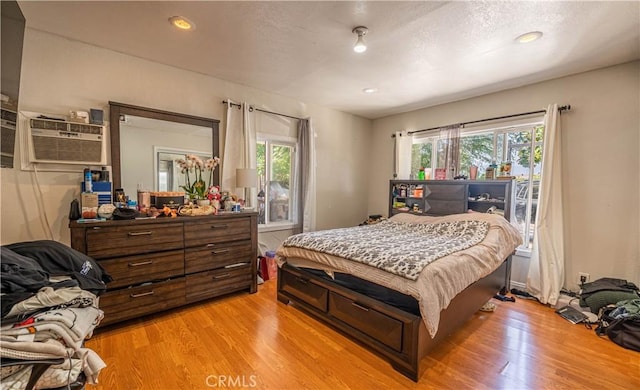 bedroom featuring multiple windows and light wood finished floors