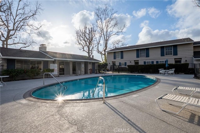 pool with a patio and fence