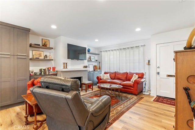 living area featuring recessed lighting, a fireplace, and light wood-style flooring