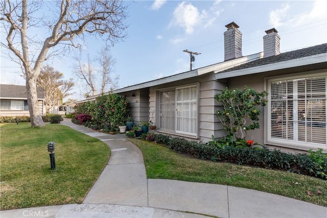 exterior space with a yard and a chimney