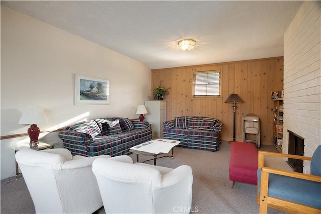 carpeted living area with wood walls and a fireplace