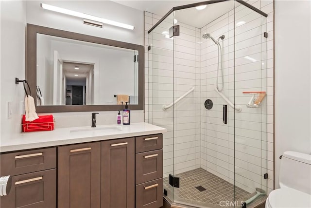 bathroom featuring a stall shower, vanity, and toilet