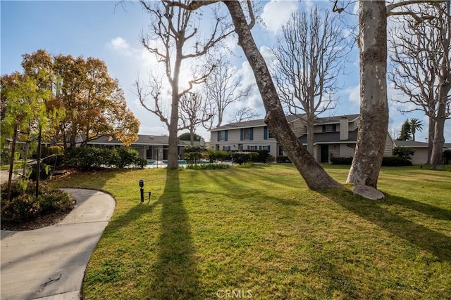 view of community with a yard and a swimming pool