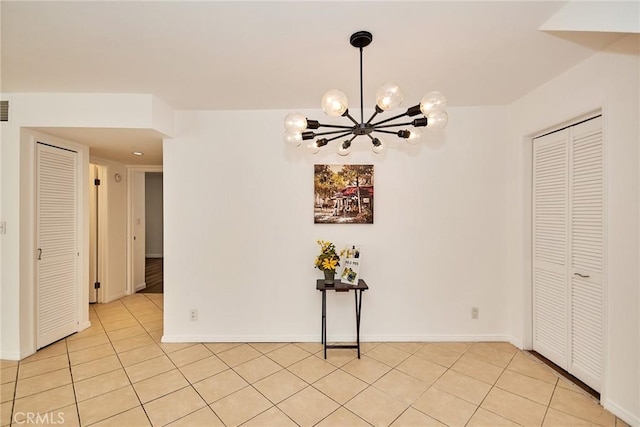 spare room featuring light tile patterned floors, a chandelier, visible vents, and baseboards