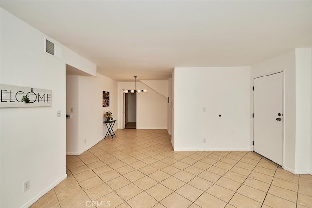 spare room with baseboards, visible vents, and light tile patterned flooring