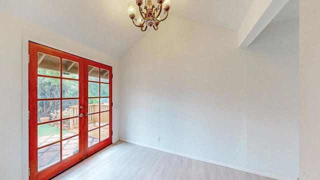 empty room featuring baseboards, wood finished floors, an inviting chandelier, vaulted ceiling, and french doors