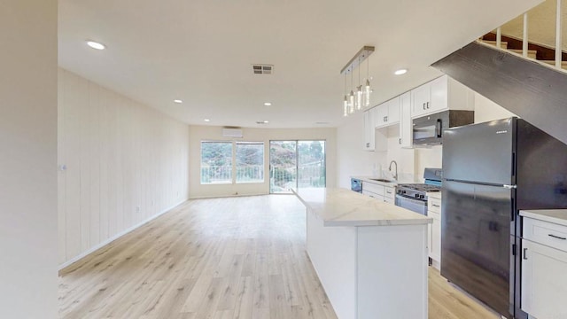 kitchen featuring black appliances, white cabinetry, visible vents, and light wood-style floors