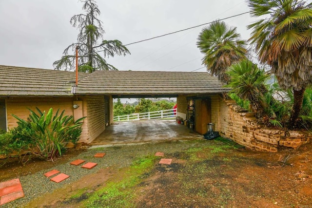 garage featuring fence and a carport