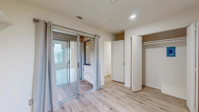 unfurnished bedroom featuring a closet, visible vents, and light wood finished floors