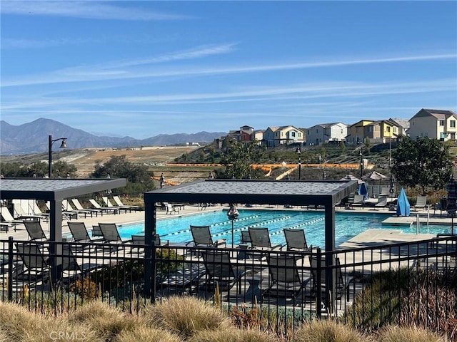 community pool featuring a patio, fence, and a mountain view