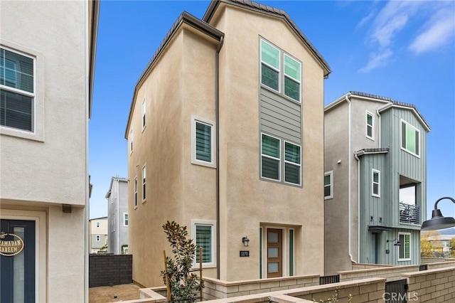 rear view of property with fence and stucco siding