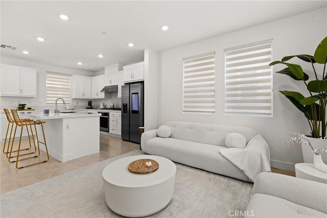 living room featuring light tile patterned flooring, visible vents, and recessed lighting