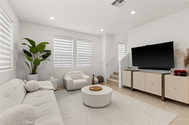 living room with stairway, light tile patterned flooring, visible vents, and recessed lighting