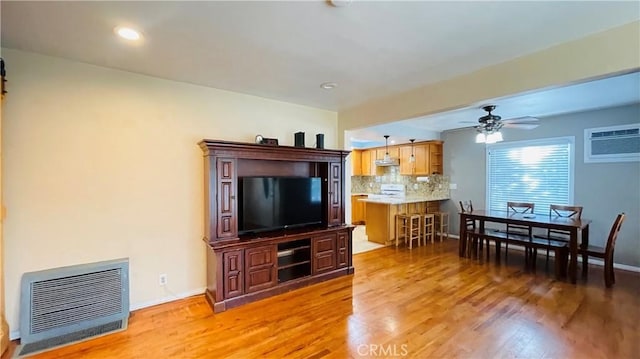 living room with recessed lighting, light wood-style floors, ceiling fan, a wall mounted air conditioner, and baseboards