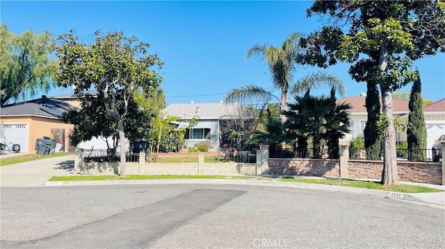 view of front facade featuring driveway and fence