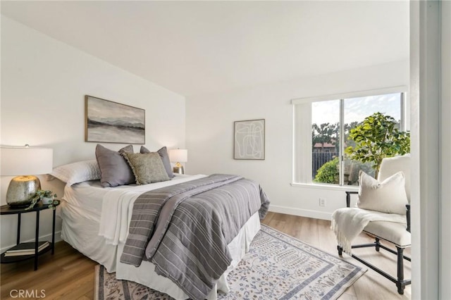 bedroom featuring wood finished floors and baseboards