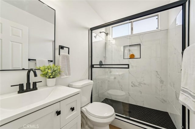 bathroom with toilet, vanity, and a marble finish shower