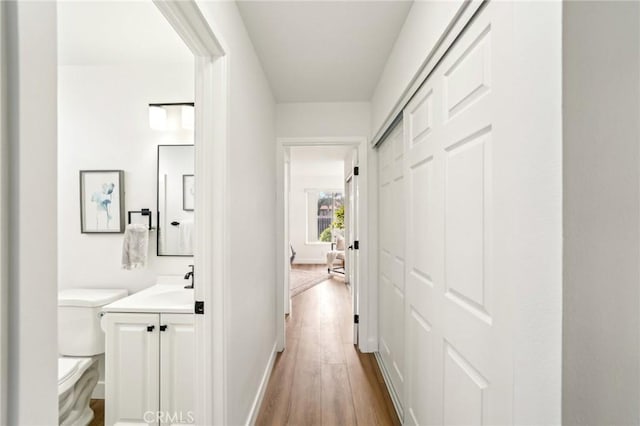 hallway with baseboards and wood finished floors