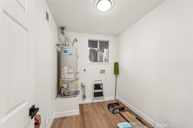 utility room with strapped water heater and visible vents