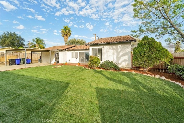 rear view of house featuring a patio area, fence, stucco siding, and a yard