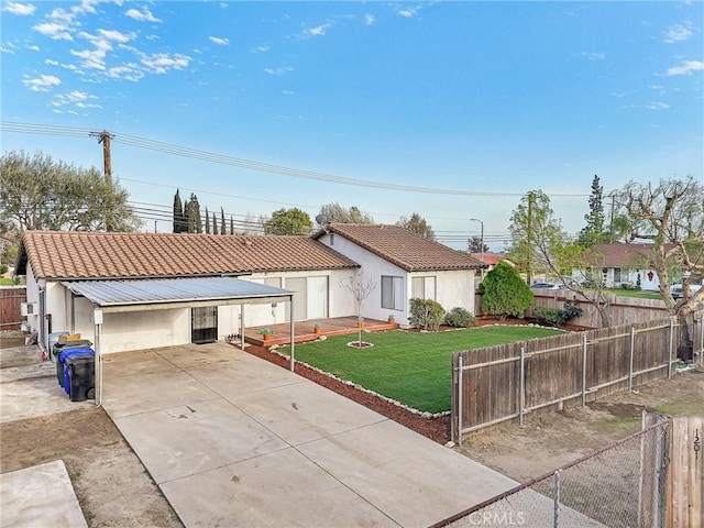 view of front of home featuring fence, a tile roof, driveway, a carport, and a front yard