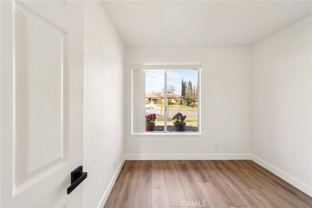 spare room with light wood-style flooring and baseboards