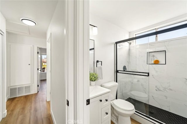 bathroom with toilet, wood finished floors, a marble finish shower, and visible vents