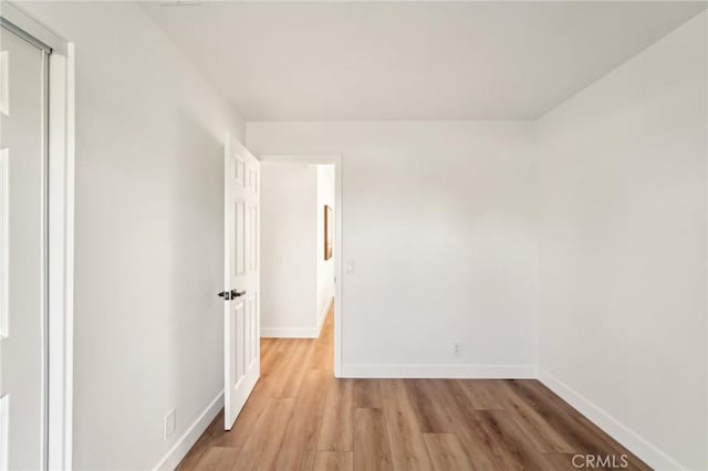 spare room with light wood-type flooring and baseboards