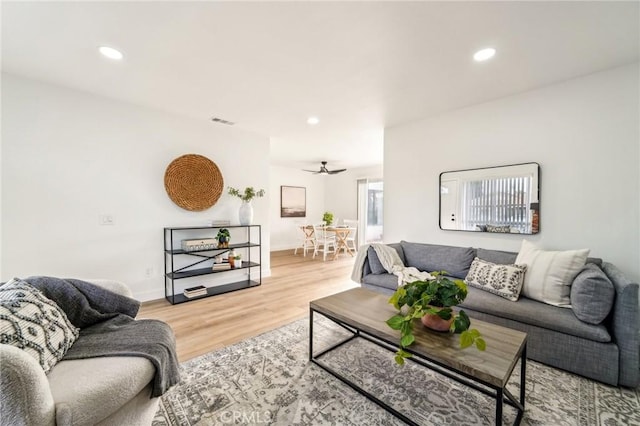 living area featuring baseboards, light wood finished floors, visible vents, and recessed lighting