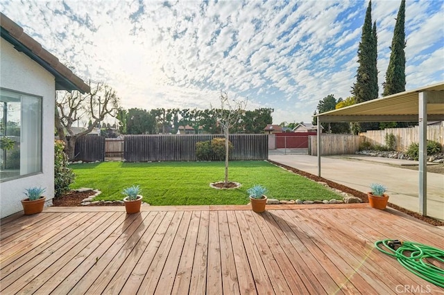 deck with a patio area, a fenced backyard, and a lawn