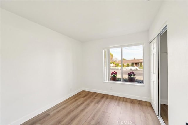 empty room featuring light wood-style floors and baseboards