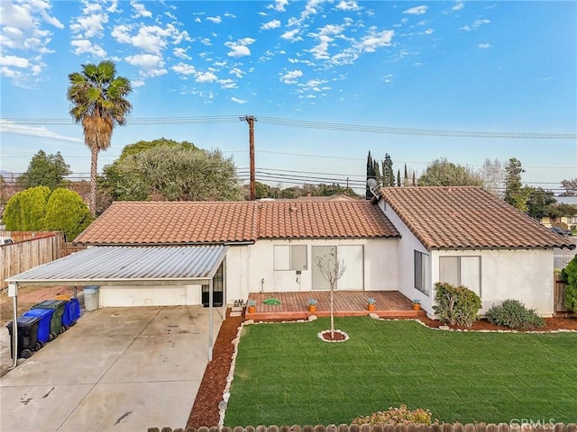 mediterranean / spanish house featuring a tiled roof, concrete driveway, stucco siding, a carport, and a front yard