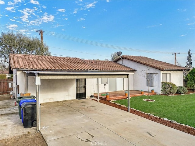 mediterranean / spanish-style home with a front yard, a tile roof, fence, and stucco siding