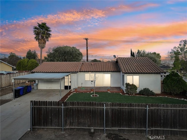 view of front of home with driveway, a tile roof, fence private yard, and stucco siding