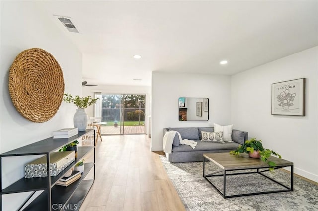 living room with baseboards, visible vents, wood finished floors, and recessed lighting