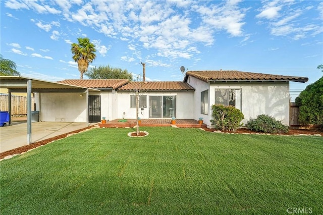 rear view of house featuring concrete driveway, a lawn, a tiled roof, a carport, and stucco siding