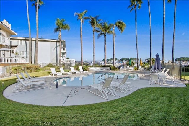 community pool with fence, a lawn, and a patio