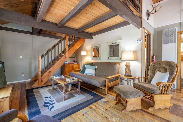 living room with beam ceiling, stairway, and hardwood / wood-style floors